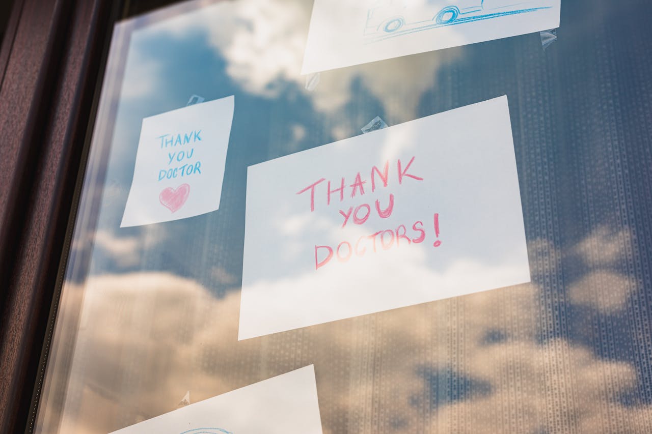 Handwritten thank you notes to doctors taped on a window, reflecting gratitude in challenging times.